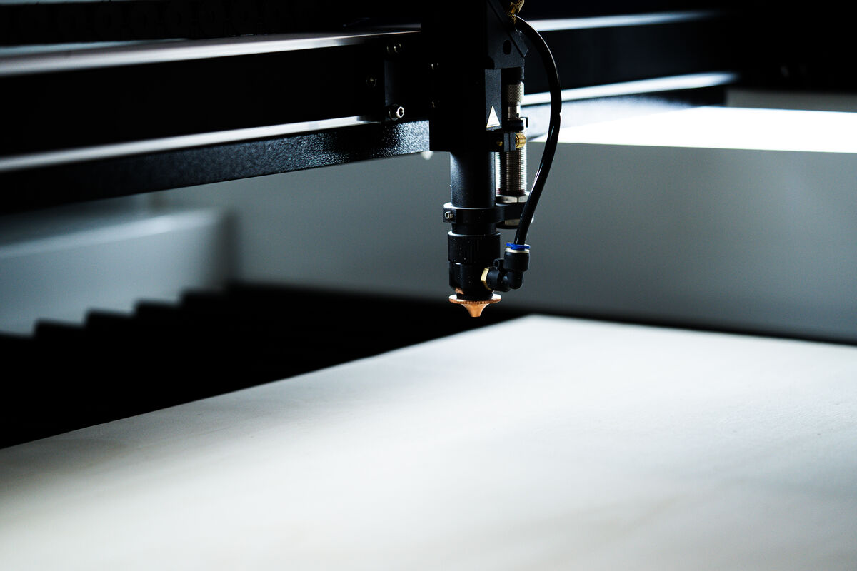 Laserkopf einer BRM Maschine über einer grossformatigen hellen Holzplatte.